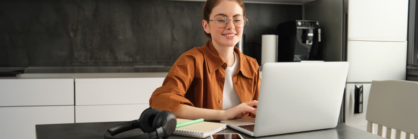 Une apprenante travaille sur ordinateur avec un casque à proximité